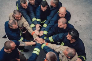 Canadian Firefighters putting hands into the center of a circle wearing PPE Fire protection gear